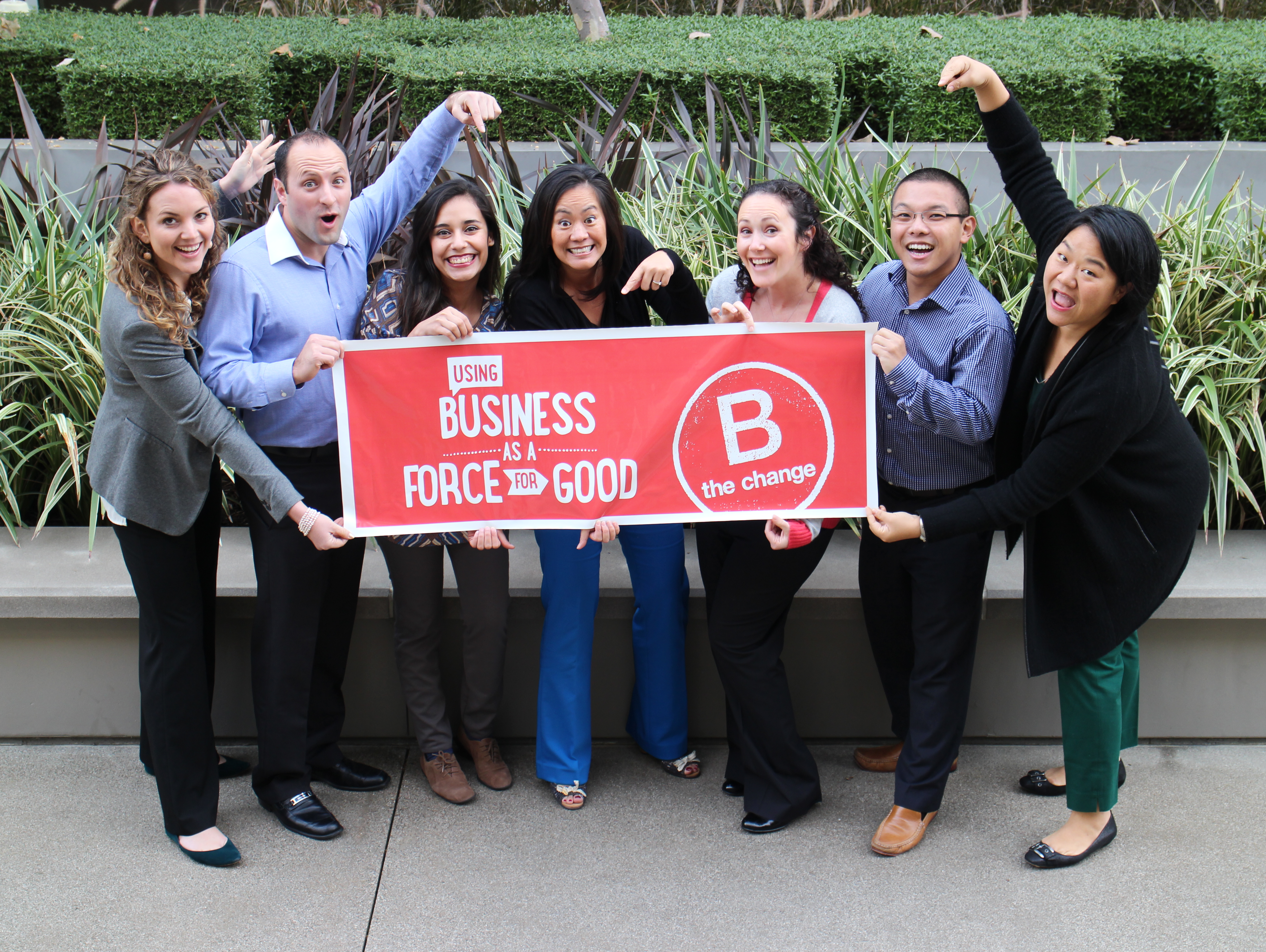 Blue Garnet team holding a "Business as a Force for Good" sign