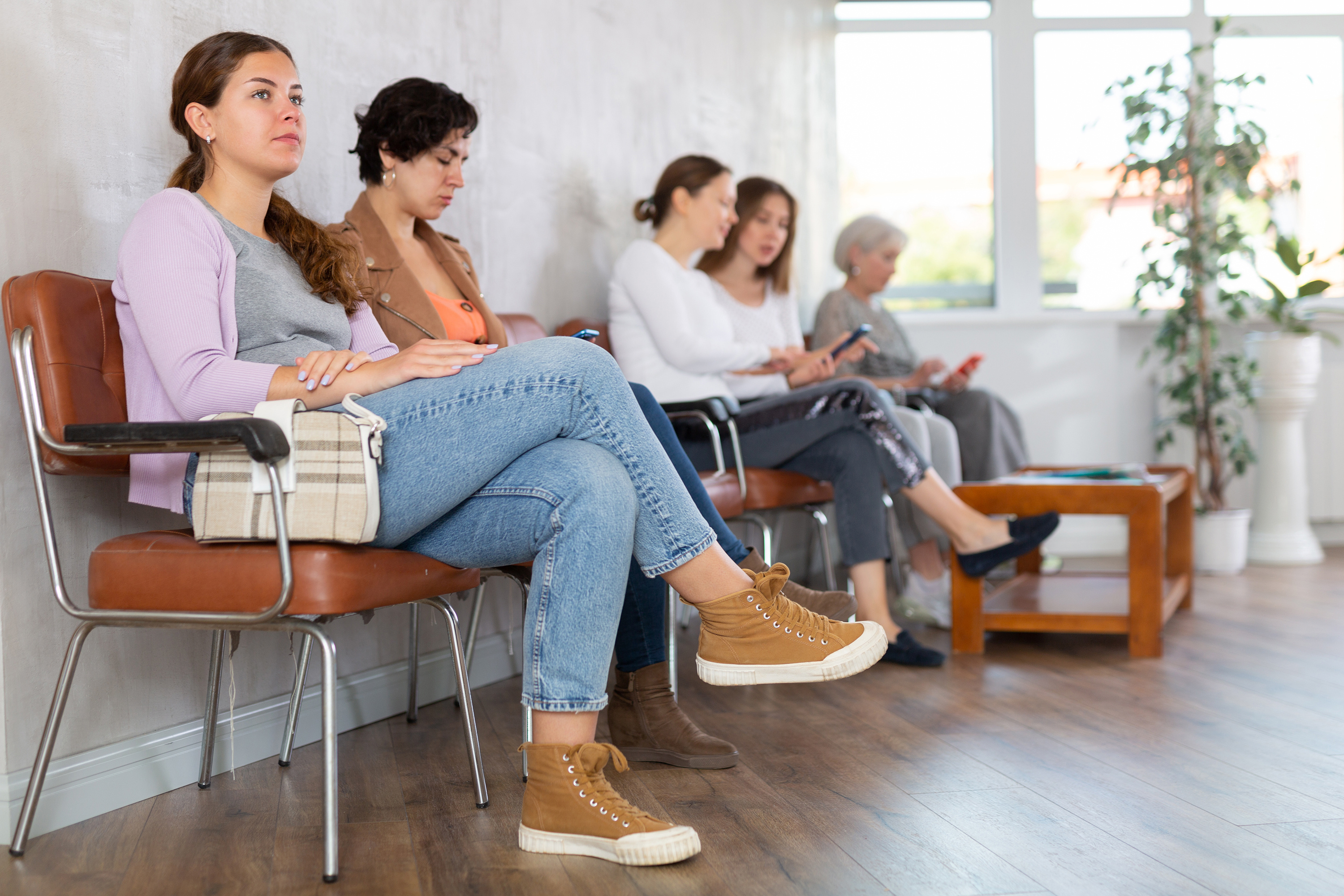 Several people sit in a waiting room