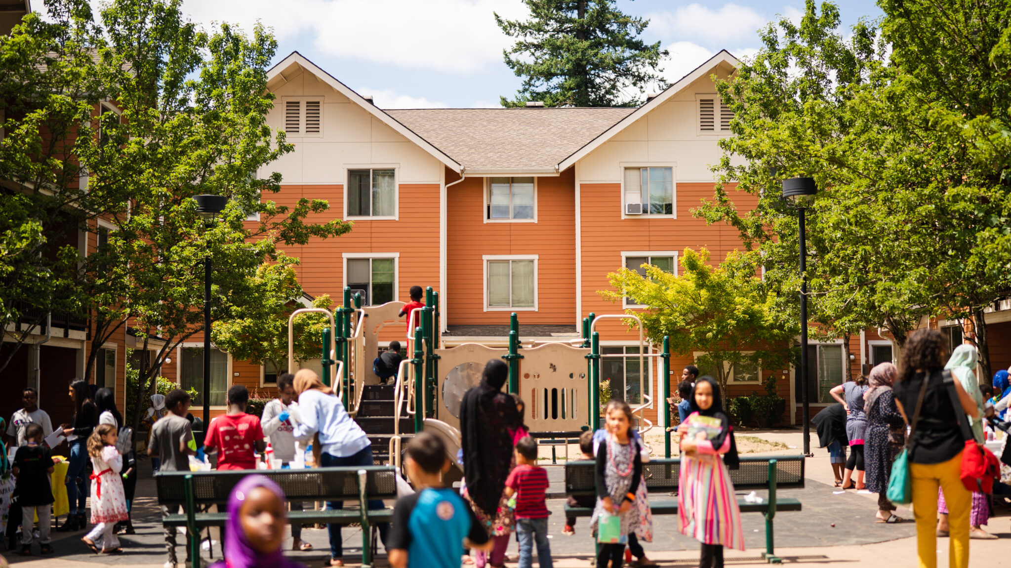 Children playing on a playground, outside of an affordable housing development