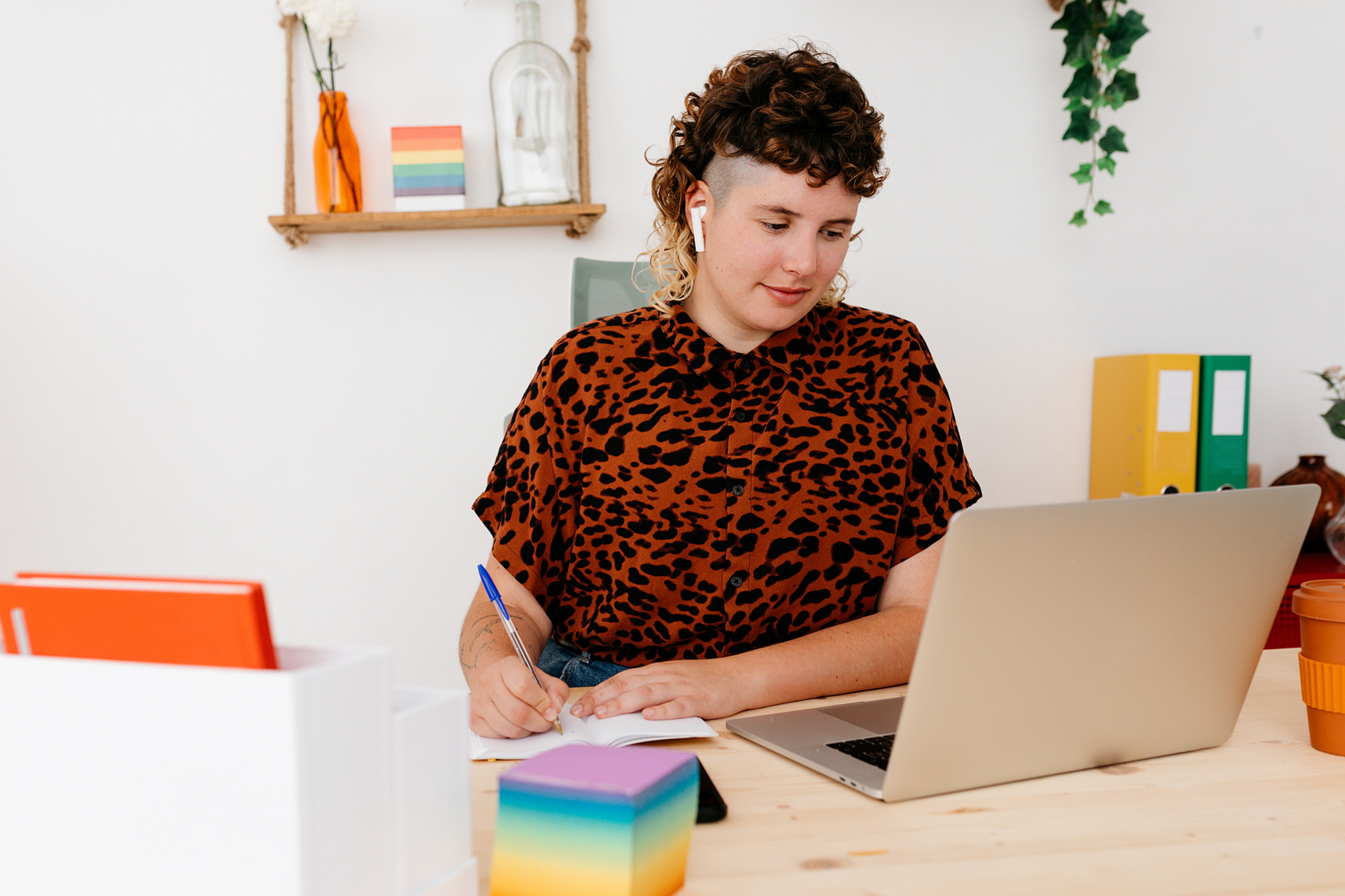 Person Writing in Notebook and Looking at Computer