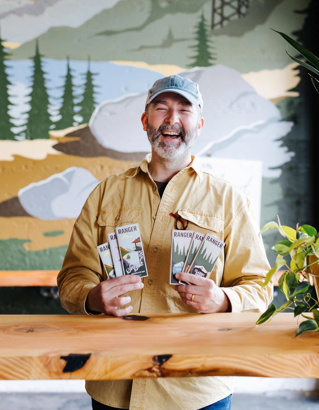 A man laughs while holding bars of chocolates