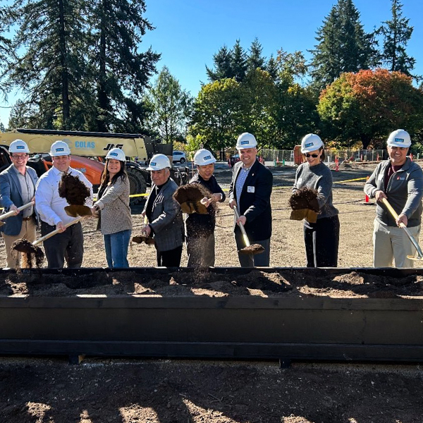 The groundbreaking of a new development project in Seattle, with people lined up with shovels.