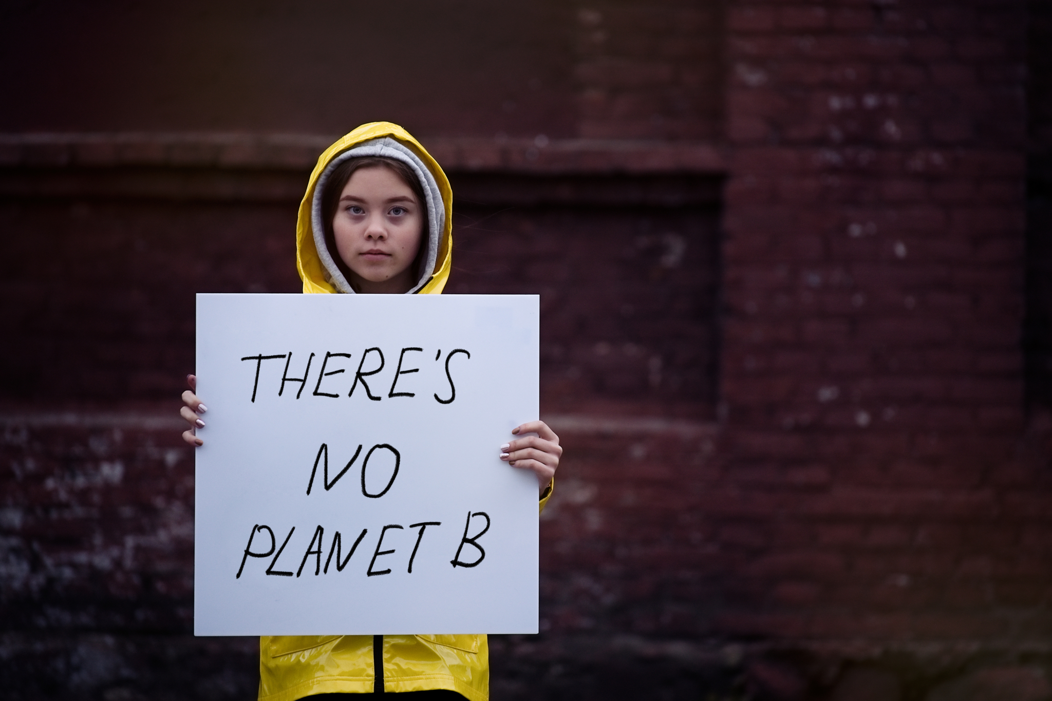 Girl holding sign with the text "There's No Planet B"