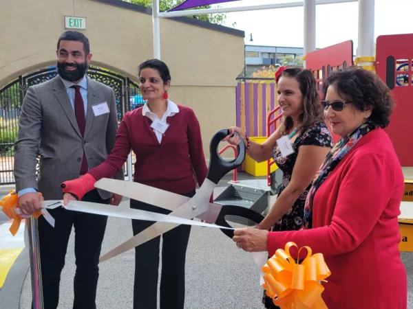 Four people pose for a ribbon cutting at Plazita Schools