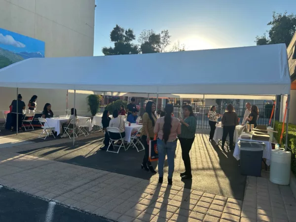 People standing under tents at Beneficial State Bank's Porterville location, gathering for the Career Fair.