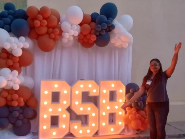 Isabella Smith, Beneficial State Bank's recruiter, stands in front of a celebratory display of light-up BSB letters and balloons at our Porterville location.