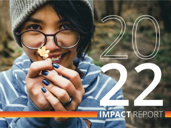Smiling woman holding flower with 2022 Impact Report text