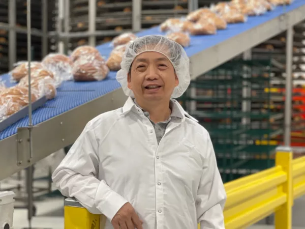 Dinh Nguy stands in front of packaged bread in his West Sacramento bakery.