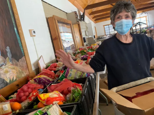 A woman in a mask packages food for distribution, a service of Idyllwild Forest Health Project's mutual aid effort