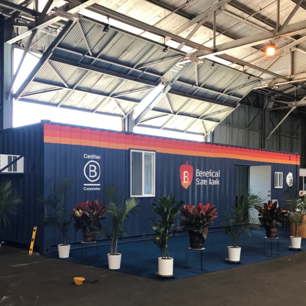 The exterior of the Beneficial State Bank Loan Production Office shipping container, with potted plants around it.