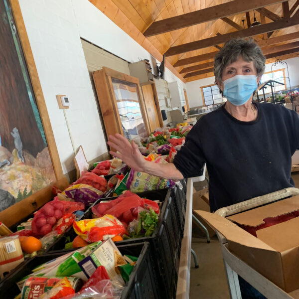 A woman in a mask packages food for distribution, a service of Idyllwild Forest Health Project's mutual aid effort