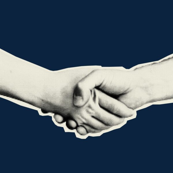 Two hands clasped in a handshake on top of a navy blue background