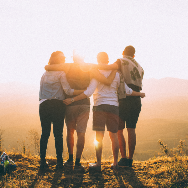 Four People Arms Interlocked Supporting Each Other, Facing Away