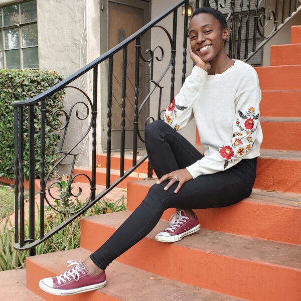 Beneficial State Bank client Alyssa Ndombeson, owner of Good Fill in Fresno, sits on steps, smiling at the camera.