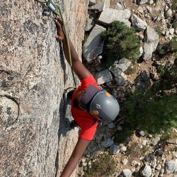 GirlVentures on the rise - a girl photographed from above as she climbs up the side of a sheer rock
