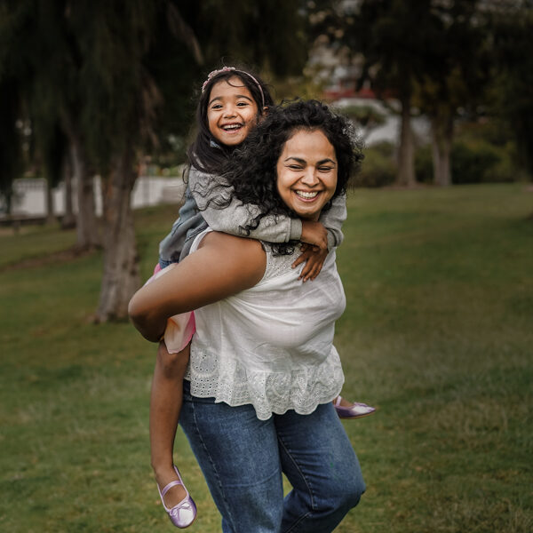 Woman smiling with child on her back