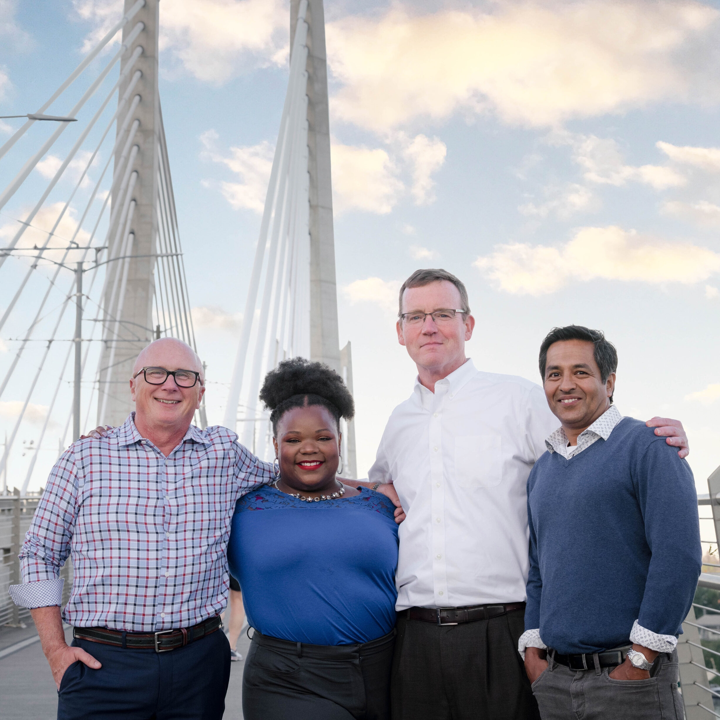 Four people stand on a bridge